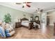 This main bedroom features a stately, solid wood carved bed, decorative accents, bedside tables, and ensuite access at 14426 W Becker Ln, Surprise, AZ 85379