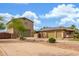 Charming home exterior with a detached garage, solar panels, and desert landscaping at 14426 W Becker Ln, Surprise, AZ 85379