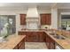 Gourmet kitchen with dark wood cabinetry, granite counters, and stainless steel appliances at 14426 W Becker Ln, Surprise, AZ 85379