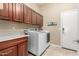 Well-equipped laundry room with modern washer and dryer, cabinets, and granite countertop at 14426 W Becker Ln, Surprise, AZ 85379