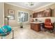 This executive home office features custom wood cabinets, granite counters, tile floors, and a window with plantation shutters at 14426 W Becker Ln, Surprise, AZ 85379