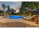 A luxurious backyard pool with beautiful landscaping and comfortable lounge chairs at twilight at 14426 W Becker Ln, Surprise, AZ 85379