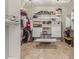 This walk-in closet features custom shelving and ample storage space with an integrated bench and tile floors at 14426 W Becker Ln, Surprise, AZ 85379