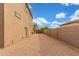 Long backyard with gravel, a privacy wall and a gate at 14426 W Becker Ln, Surprise, AZ 85379