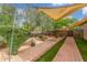 Serene backyard featuring rock features, desert landscaping, and a covered patio area at 14426 W Becker Ln, Surprise, AZ 85379