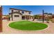 Lush backyard with a pool, and artificial grass offers relaxation and entertainment options at 15683 W Minnezona Ave, Goodyear, AZ 85395