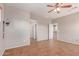 Bedroom with tile flooring, neutral paint, ceiling fan, and access to hallway and bathroom at 15683 W Minnezona Ave, Goodyear, AZ 85395