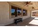 Spacious covered patio with ceiling fans, large windows, and a bench for outdoor relaxation at 15683 W Minnezona Ave, Goodyear, AZ 85395