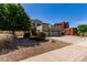 Beige two-story house with desert landscaping, a three-car garage, and a spacious driveway at 15683 W Minnezona Ave, Goodyear, AZ 85395