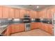 Spacious kitchen features wood cabinets, stainless steel appliances, and black granite countertops at 15683 W Minnezona Ave, Goodyear, AZ 85395