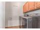 Functional laundry room with modern washer and dryer, plus overhead cabinets at 15683 W Minnezona Ave, Goodyear, AZ 85395