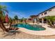 Backyard pool surrounded by lush landscaping, a patio area, and a well-maintained lawn at 15683 W Minnezona Ave, Goodyear, AZ 85395