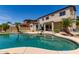 Stunning pool area with a unique shape, rock features, and mature palm trees at 15683 W Minnezona Ave, Goodyear, AZ 85395