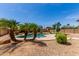 Beautiful pool with palm trees and rock features create a tranquil backyard oasis at 15683 W Minnezona Ave, Goodyear, AZ 85395