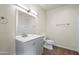 Well-lit bathroom with a modern vanity, large mirror, toilet, and neutral color scheme at 1720 W Elm St, Phoenix, AZ 85015