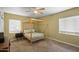 Bedroom with a four-post bed frame, carpet floors, ceiling fan, and natural lighting at 1720 W Elm St, Phoenix, AZ 85015