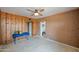 Spacious bonus room featuring a ceiling fan, and a mix of rustic adobe and wood-paneled walls at 1720 W Elm St, Phoenix, AZ 85015