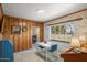 Charming dining area with brick wall, wood paneling and natural light from a window with floral curtains at 1720 W Elm St, Phoenix, AZ 85015