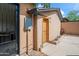 Exterior view of home, showing the light-stucco siding, wood door and a gated entryway at 1720 W Elm St, Phoenix, AZ 85015