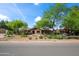 Inviting one-story home with desert landscaping including a mature tree in front at 1720 W Elm St, Phoenix, AZ 85015
