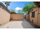 Enclosed patio area featuring a smooth concrete surface, statue, and mature trees, ideal for relaxing at 1720 W Elm St, Phoenix, AZ 85015