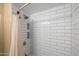 Shower featuring white subway tile and built-in storage shelves at 1720 W Elm St, Phoenix, AZ 85015