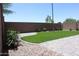 Landscaped backyard with artificial turf, flower bushes, and brick paver accents at 20217 W Desert Bloom St, Buckeye, AZ 85326