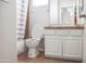 This bathroom features a single vanity, toilet and bathtub and shower combination with white trim and neutral walls at 20217 W Desert Bloom St, Buckeye, AZ 85326