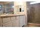 Bathroom with a double sink, shower, vanity, and mirrors that make getting ready easy at 20217 W Desert Bloom St, Buckeye, AZ 85326