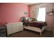 Colorful bedroom with a double bed, dresser, and bright pink walls at 20217 W Desert Bloom St, Buckeye, AZ 85326