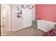 View of a charming bedroom, closet, white dresser, and pink walls at 20217 W Desert Bloom St, Buckeye, AZ 85326