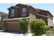 Two-story home with an attached garage and well-manicured landscaping in the front yard at 20217 W Desert Bloom St, Buckeye, AZ 85326
