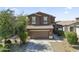 Exterior view of a two-story home showcasing a tiled roof, front yard desert landscaping and a two-car garage at 20217 W Desert Bloom St, Buckeye, AZ 85326