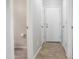 Hallway showing multiple doors including access to a half bathroom at 20217 W Desert Bloom St, Buckeye, AZ 85326