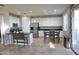 Spacious kitchen features white cabinetry, stainless steel appliances, and an island with bar seating at 20217 W Desert Bloom St, Buckeye, AZ 85326