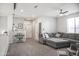 The spacious living room features plush gray sectional sofa and stairs with white railings at 20217 W Desert Bloom St, Buckeye, AZ 85326