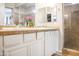 Bright bathroom featuring a double vanity with mirrors, white cabinetry, tile floors and shower at 20217 W Desert Bloom St, Buckeye, AZ 85326
