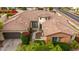 Aerial view of a home showcasing its landscaped front yard, brick accents, unique circular tower, and tile roof at 20532 W Summit Pl, Buckeye, AZ 85396