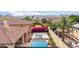 Backyard view with pool, basketball court and lounge chairs surrounded by colorful bougainvillea at 20532 W Summit Pl, Buckeye, AZ 85396