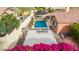Aerial view of a backyard with pool, outdoor kitchen, basketball court, and vibrant flowers at 20532 W Summit Pl, Buckeye, AZ 85396