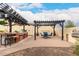 Spacious backyard with an outdoor kitchen, bar, pergola, fireplace, and comfortable seating areas, ideal for gatherings at 20532 W Summit Pl, Buckeye, AZ 85396