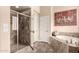 Bright bathroom with a glass-enclosed shower and a tiled soaking tub, providing a luxurious bathing experience at 20532 W Summit Pl, Buckeye, AZ 85396
