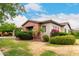 Beautifully landscaped single-Gathering home featuring manicured desert landscaping, flowering bushes, and mature shade trees at 20532 W Summit Pl, Buckeye, AZ 85396