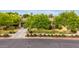 Street view of a beautiful home with mature trees, a well-kept lawn, and manicured shrubbery, offering great curb appeal at 20532 W Summit Pl, Buckeye, AZ 85396