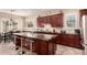 Open-concept kitchen features dark wood cabinets, granite countertops, stainless steel appliances, and a central island at 20532 W Summit Pl, Buckeye, AZ 85396