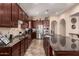 Beautiful kitchen with dark wood cabinets, stainless steel appliances, granite countertops, and tile backsplash at 20532 W Summit Pl, Buckeye, AZ 85396