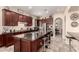 Spacious kitchen with dark wood cabinetry, stainless steel appliances, granite counters, and a large island with seating at 20532 W Summit Pl, Buckeye, AZ 85396