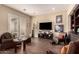 Comfortable living room featuring wood floors, a built-in bookcase, a large screen television, and direct access to the outdoors at 20532 W Summit Pl, Buckeye, AZ 85396