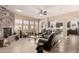 Bright living room featuring a stone fireplace, tile flooring, comfortable seating, and an open layout at 20532 W Summit Pl, Buckeye, AZ 85396