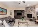 Inviting living room features a stone fireplace, a built-in media center, and a comfortable gray sofa at 20532 W Summit Pl, Buckeye, AZ 85396